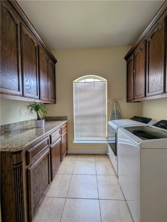 laundry area featuring cabinet space, independent washer and dryer, and light tile patterned floors