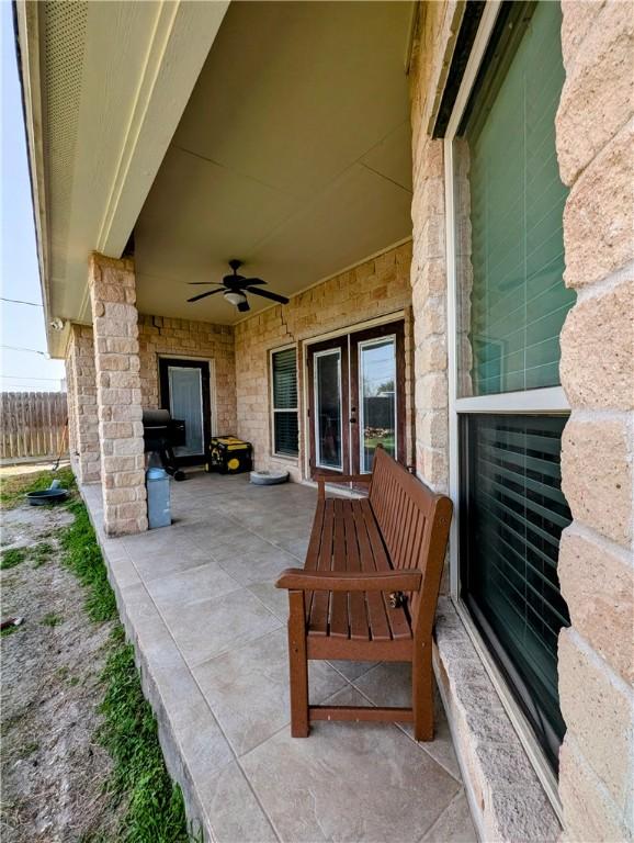 view of patio featuring ceiling fan and fence