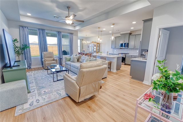 2634 Westeros St, Corpus Christi, TX 78415 - living area with a raised ceiling, a ceiling fan, a chandelier, light wood finished floors, and recessed lighting