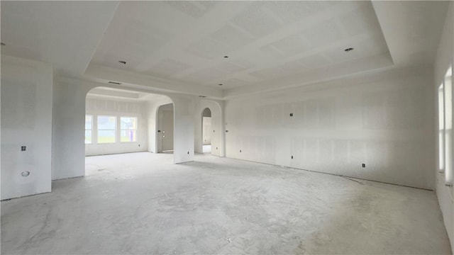 empty room featuring arched walkways and concrete floors