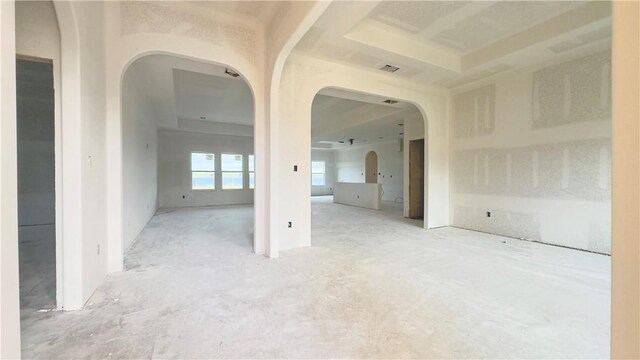 unfurnished room featuring arched walkways and visible vents