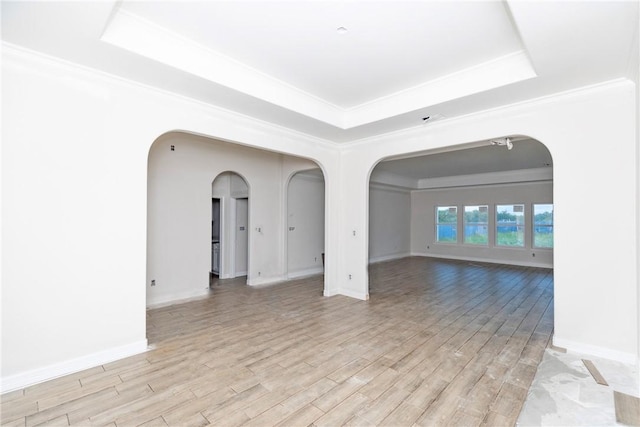 112 Shoalwater Way, Rockport, TX 78382 - spare room with a raised ceiling, light wood-type flooring, crown molding, and arched walkways