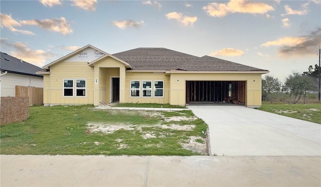 view of front facade with concrete driveway, an attached garage, fence, board and batten siding, and a front yard