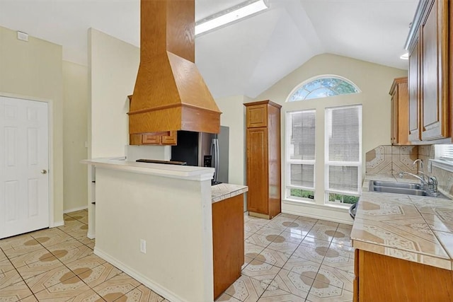 1225 Calle, San Carlos, Corpus Christi, TX 78417 - kitchen with stainless steel fridge with ice dispenser, a peninsula, lofted ceiling, brown cabinetry, and light countertops
