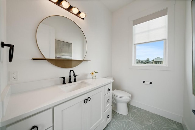 bathroom with toilet, baseboards, and vanity