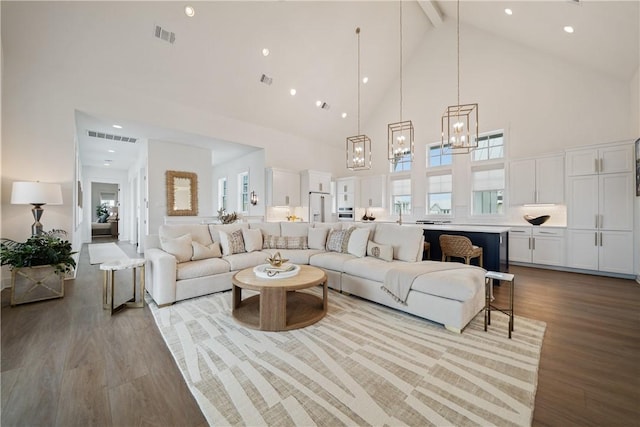 living room featuring high vaulted ceiling, visible vents, beamed ceiling, and wood finished floors