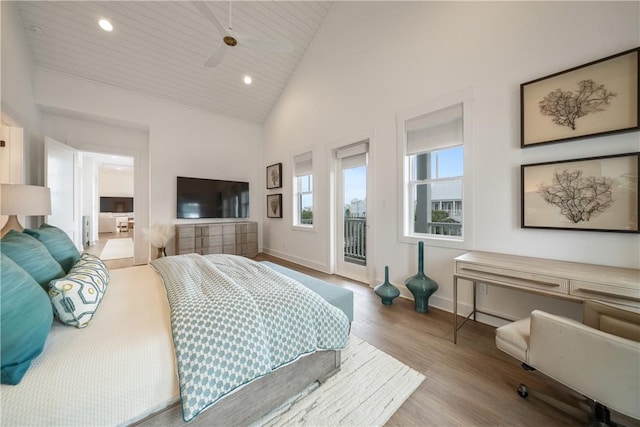 bedroom with access to exterior, recessed lighting, wood finished floors, high vaulted ceiling, and baseboards