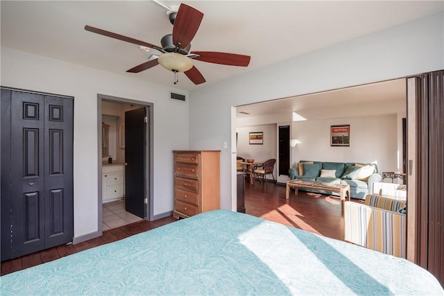 bedroom featuring ensuite bathroom, dark wood-type flooring, ceiling fan, and a closet