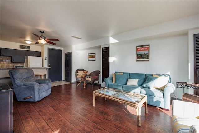 living room featuring ceiling fan and dark hardwood / wood-style floors