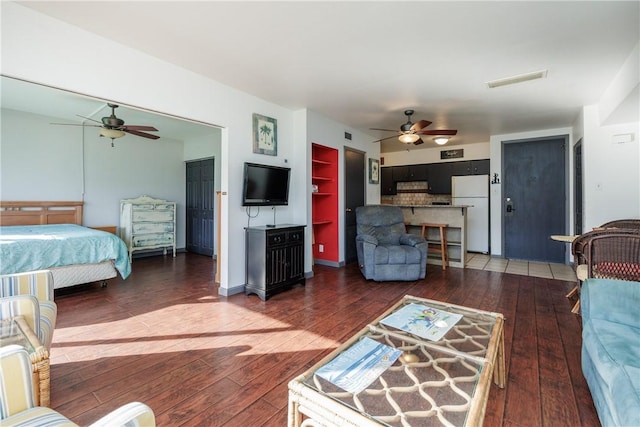 bedroom featuring ceiling fan, white refrigerator, and dark hardwood / wood-style floors