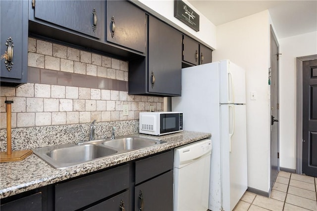 kitchen featuring white dishwasher, sink, light tile patterned floors, and decorative backsplash