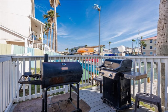 wooden terrace featuring area for grilling and a water view