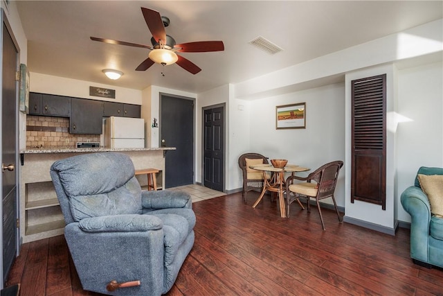 living room featuring ceiling fan and dark wood-type flooring