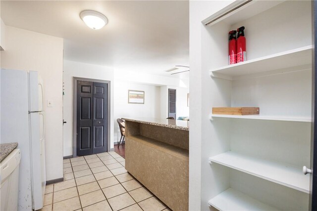 kitchen featuring white appliances and light tile patterned flooring