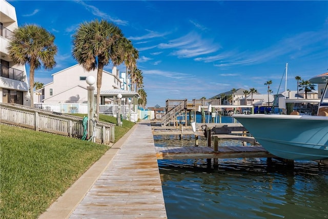 dock area featuring a lawn and a water view