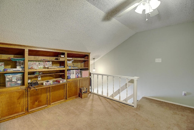 interior space with a textured ceiling, ceiling fan, and vaulted ceiling