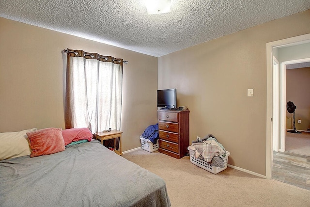 bedroom featuring a textured ceiling and light carpet