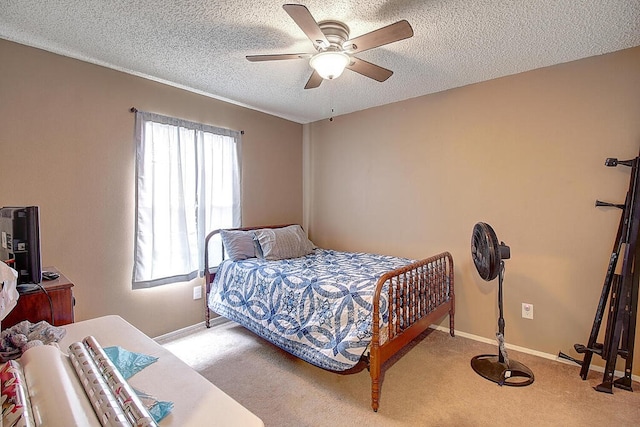 bedroom featuring a textured ceiling, light colored carpet, and ceiling fan