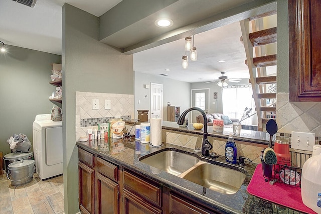 kitchen featuring light hardwood / wood-style floors, sink, ceiling fan, washer / dryer, and decorative backsplash