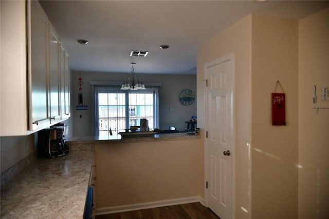 kitchen with pendant lighting, visible vents, white cabinetry, a chandelier, and a peninsula