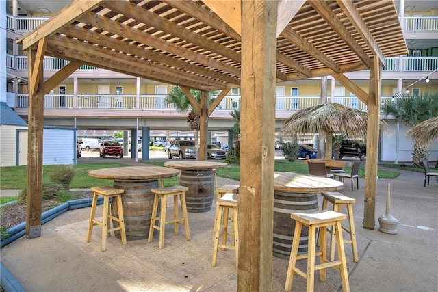 view of patio with exterior bar and a pergola