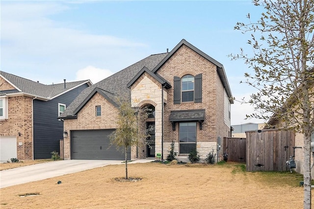 view of front of house featuring stone siding, fence, brick siding, and driveway