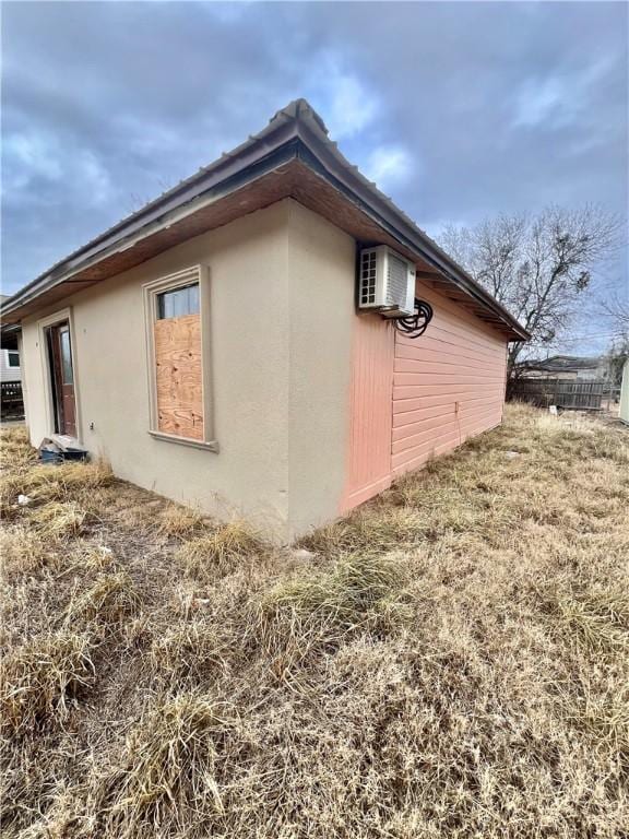 view of side of property featuring a wall mounted AC