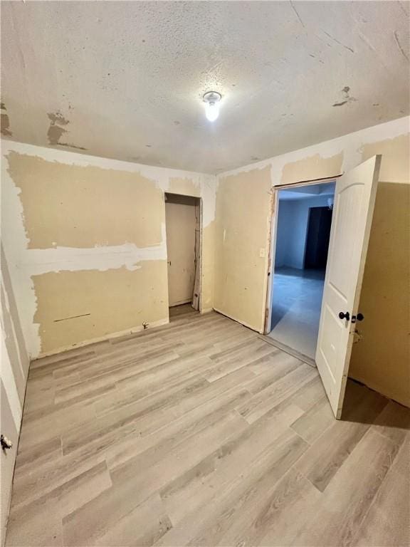 unfurnished room featuring hardwood / wood-style flooring and a textured ceiling