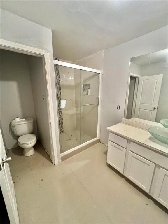 bathroom with an enclosed shower, vanity, and toilet