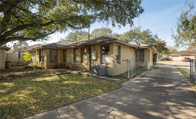 view of front of house with a front lawn and central air condition unit