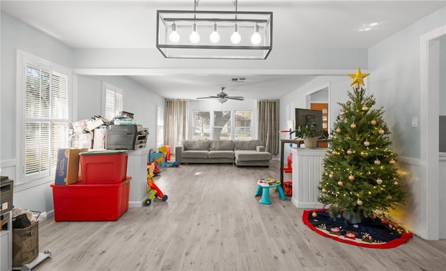 living room with ceiling fan, a healthy amount of sunlight, and light wood-type flooring