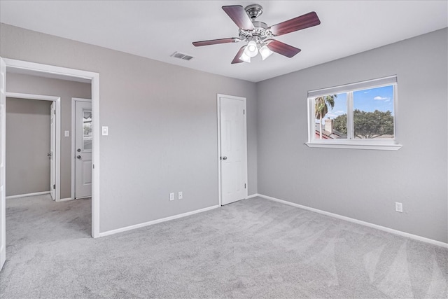 carpeted spare room featuring ceiling fan