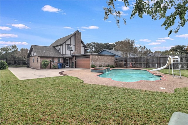 view of swimming pool with an in ground hot tub, a yard, a patio, and a water slide