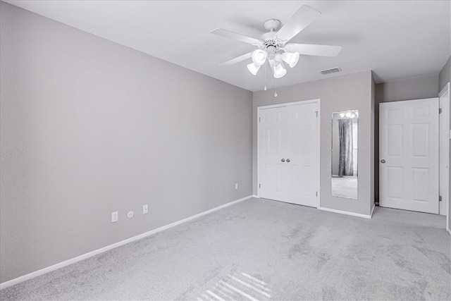 unfurnished bedroom with ceiling fan, a closet, and light carpet