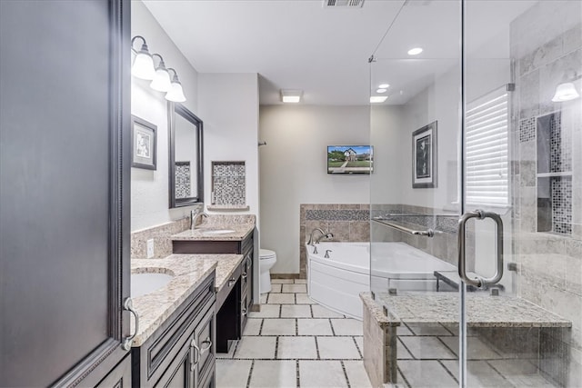 bathroom featuring tile patterned flooring, vanity, toilet, and a tub to relax in