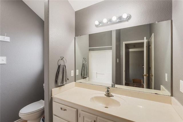 bathroom with vanity, toilet, and a shower