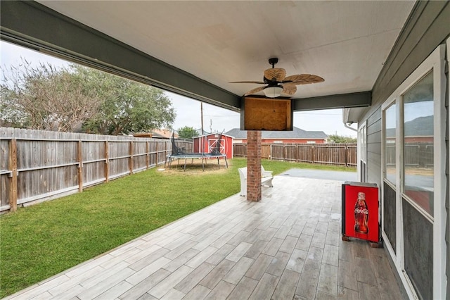 view of patio featuring ceiling fan and a storage unit