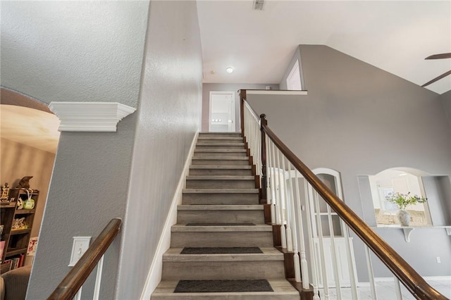 staircase with high vaulted ceiling