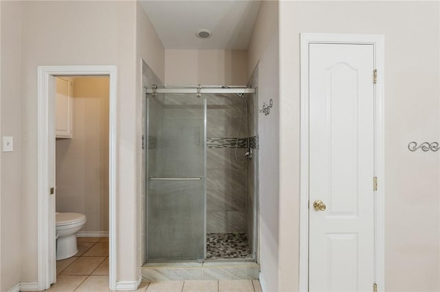 bathroom featuring walk in shower, toilet, and tile patterned flooring