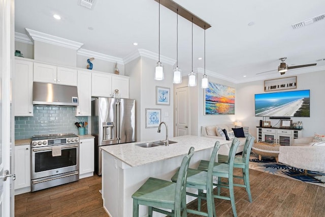 kitchen with visible vents, appliances with stainless steel finishes, a sink, open floor plan, and under cabinet range hood