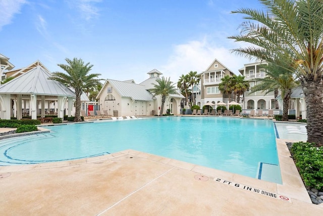 community pool featuring a residential view and a patio