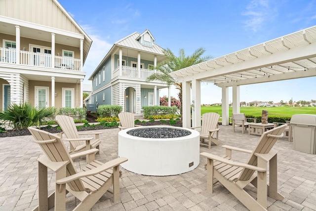 view of patio featuring a pergola, a fire pit, and a balcony