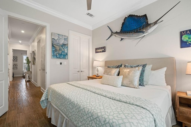 bedroom featuring wood-type flooring, baseboards, visible vents, ornamental molding, and a closet