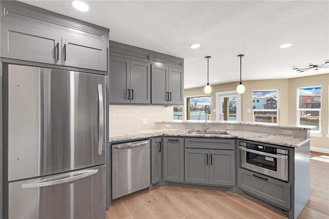 15334 Key Largo Ct, Corpus Christi, TX 78418 - kitchen with appliances with stainless steel finishes, gray cabinets, a peninsula, a sink, and light wood finished floors