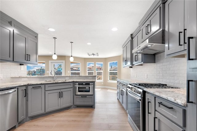 15334 Key Largo Ct, Corpus Christi, TX 78418 - kitchen featuring appliances with stainless steel finishes, a sink, under cabinet range hood, a peninsula, and gray cabinetry