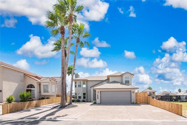 15334 Key Largo Ct, Corpus Christi, TX 78418 - view of front of house featuring stucco siding, fence, a garage, concrete driveway, and a residential view