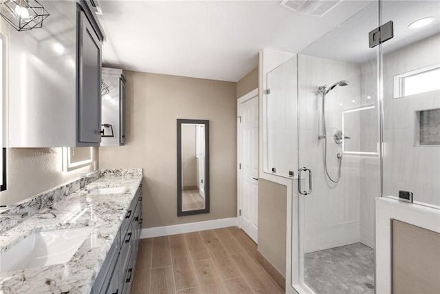 15334 Key Largo Ct, Corpus Christi, TX 78418 - bathroom with a shower stall, wood finished floors, double vanity, and baseboards