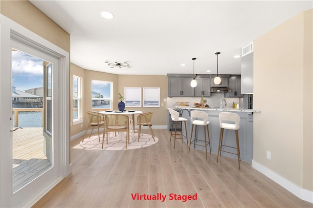 15334 Key Largo Ct, Corpus Christi, TX 78418 - kitchen featuring a breakfast bar, gray cabinets, light wood-style floors, recessed lighting, and baseboards