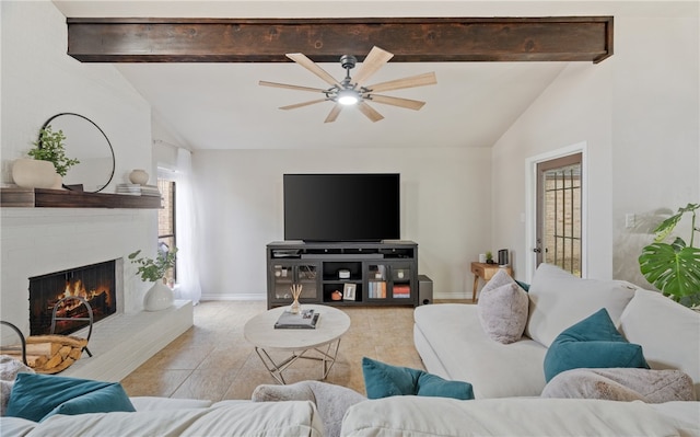 living room featuring ceiling fan, lofted ceiling with beams, and a fireplace