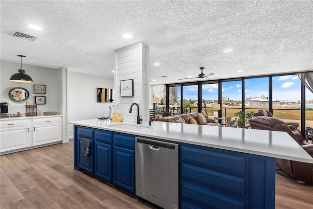 kitchen with a textured ceiling, sink, blue cabinetry, dishwasher, and hanging light fixtures